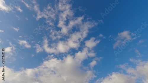 Clear blue sky with scattered moving white cumulus clouds. Time lapse weather footage for cinematic sky replacement, masking, and natural outdoor background.