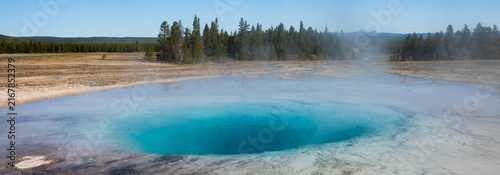 Foto Turquoise natural geothermal pool in the midway geyser basin with hot steam on a
