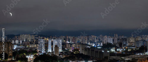 Fotografie Nighttime photo of the Lapa neighborhood in Sao Paulo featuring the waning moon and the Cantareira mountain range