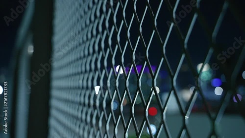 Extreme Close Up motion down along Diagonal Chain Link Fence at Night. Security Perimeter and Prison Escape Concept