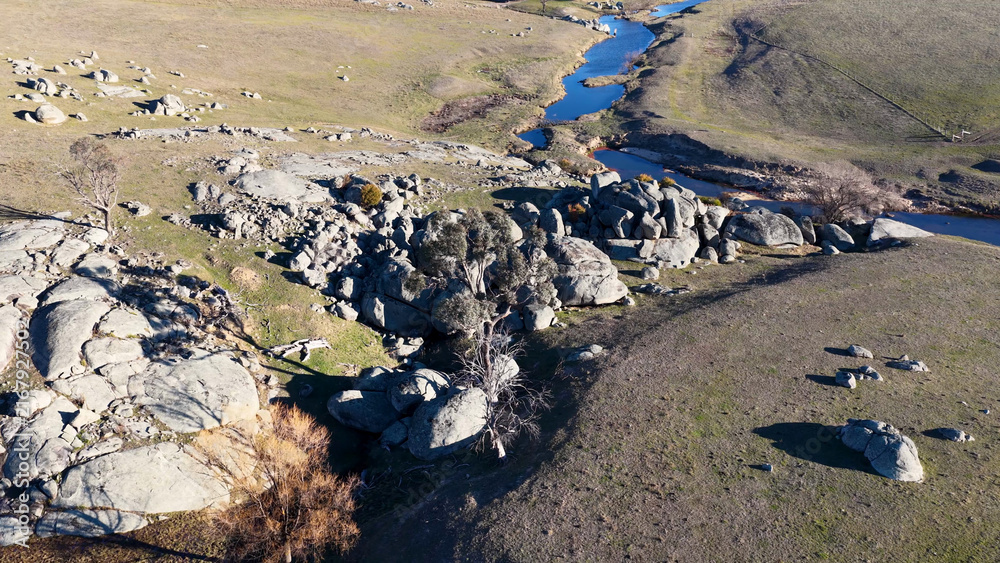 Naklejka premium Aerial View of Granite Boulders and Winding Creek in Uralla Countryside