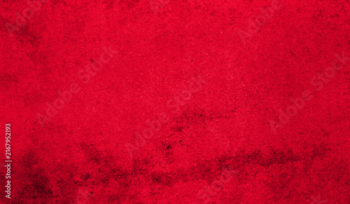 Vivid red texture with a rough surface, visible grain and irregular dark stains. Abstract grunge background ideal for design, advertising and creative projects.