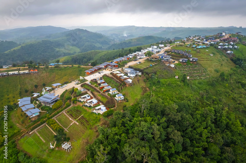 Принти на полотні High aerial drone view of resort cottages spread over lush green mountain ridge in the morning at Mon Mork Tawan, Phop Phra, Tak, Thailand