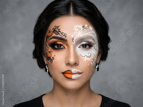 Beautiful woman portrait with creative artistic face paint and detailed makeup design
