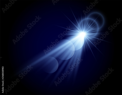 Bright blue lens flare with glowing rays and optical light effects on dark background.