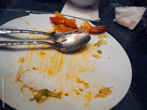 Konstfotografi A dirty plate after a meal, with leftover food and used cutlery, suggesting a sa