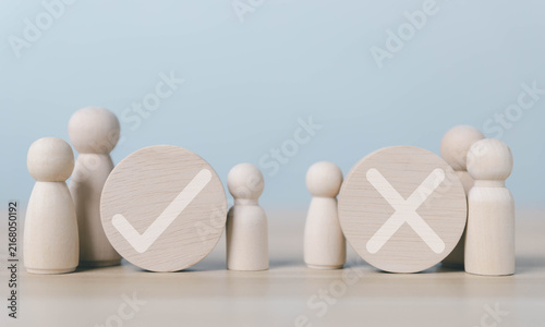 Wooden figures with yes and no symbols represent right and wrong choices, decision making, approval, rejection, voting, evaluation, judgment, business decisions, and problem solving.