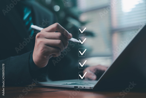 Business professional using a laptop and digital checklist to review tasks, verify information, track progress, and manage workflow, representing productivity, accuracy, compliance and decision making