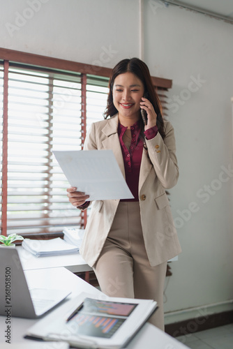 Konstfotografi Businesswoman multitasking holding document and speaking on phone