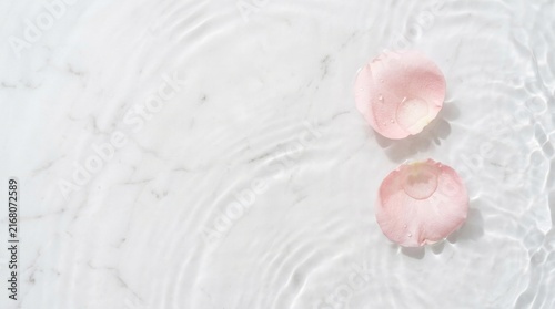 Pink Rose Petals on Rippling Water Over White Marble Background