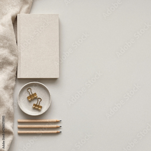 Minimalist flat lay with notebook, pencils, and binder clips on a neutral background