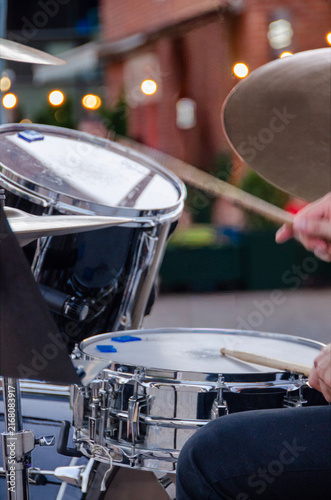 Obraz na płótnie Musician performing on drums at an outdoor concert with dynamic hands, sticks and cymbals