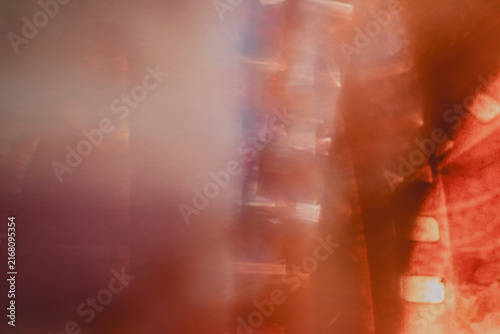 Artistic closeup of overexposed analogue camera film stripes with rainbow light leaks, radiant lens flare, translucent abstract color distortions and vintage photographic texture.