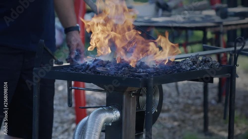 Blacksmith Tending Coal Forge Fire