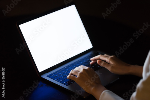 Fotografie A woman using a computer in a dark room