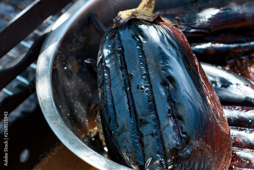 Close-up of a grilled eggplant in a metal bowl during preparation