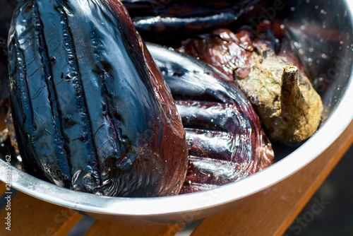 Close-up of roasted eggplants in a metal bowl prepared for cooking