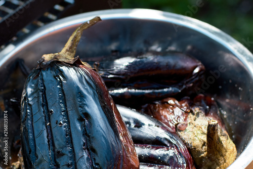 Close-up of freshly grilled eggplants in a metal bowl during preparation