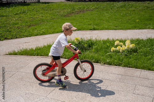 A Caucasian boy riding a bicycle. 