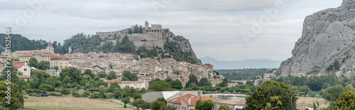 historical village on Durance river and overhanging Citadelle fortification above it at Sisteron, France