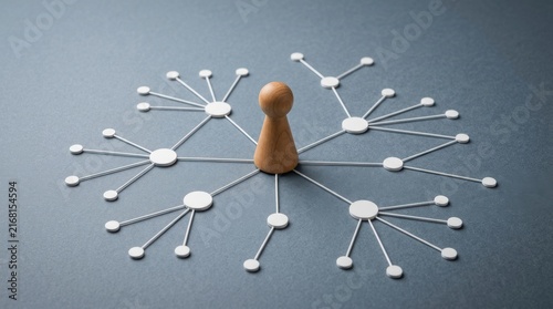 Wooden game piece in the center of a network diagram made of white circles and connectors on a dark background