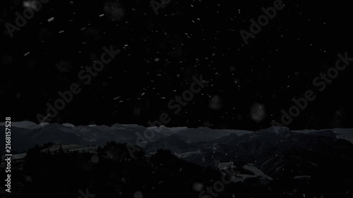 Snow is falling against the backdrop of mountains and a black background