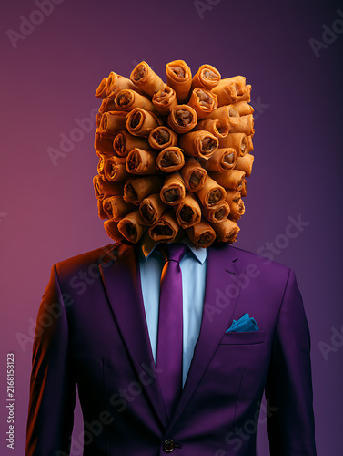 A mannequin in a dark purple suit, with a crispy spring roll as its head, empty space