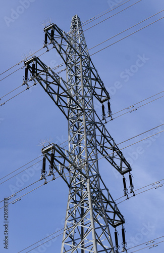 Fotografía Detailed close-up of a high voltage power line pylon structure with insulators against a clear blue sky