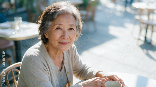 breakup in old age and a copy space with text about divorce lawyer services, a portrait of an elderly Korean-American woman at a table in an outdoor cafe, calmly making the decision to divorce