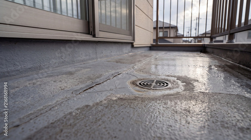 ひび割れや劣化が見られる住宅ベランダの防水床と排水口