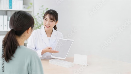 Tapety artystyczne 薬局で電子お薬手帳の画面を見ながら相談する薬剤師と患者