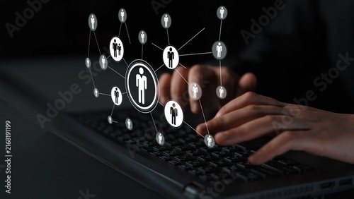 Photography Person using laptop with digital network connection visual, focusing on communication, people icons, technology, and networking in a dark environment Gluon