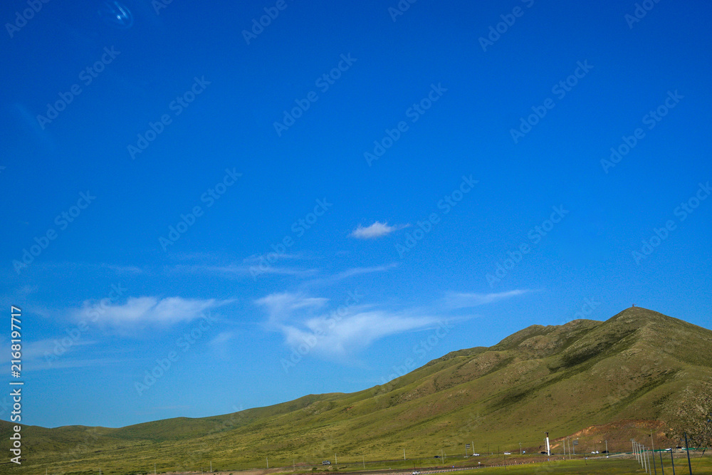 Fototapeta premium Clear Blue Sky Over Green Rolling Mountain Landscape