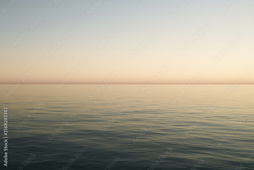 Fototapeta premium Minimalist Sunset Horizon Over Calm Sea Water with Soft Pastel Colors