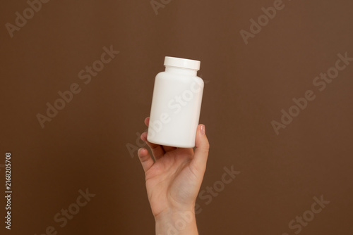 Foto Hand holding white medicine bottle for health care