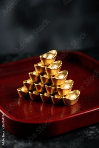 Stacked Gold Ingots Pyramid on Red Lacquered Tray Lunar New Year Background