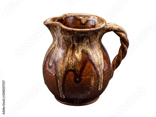 Konstfotografi Rustic brown ceramic pitcher with a unique twisted handle and drippy glaze