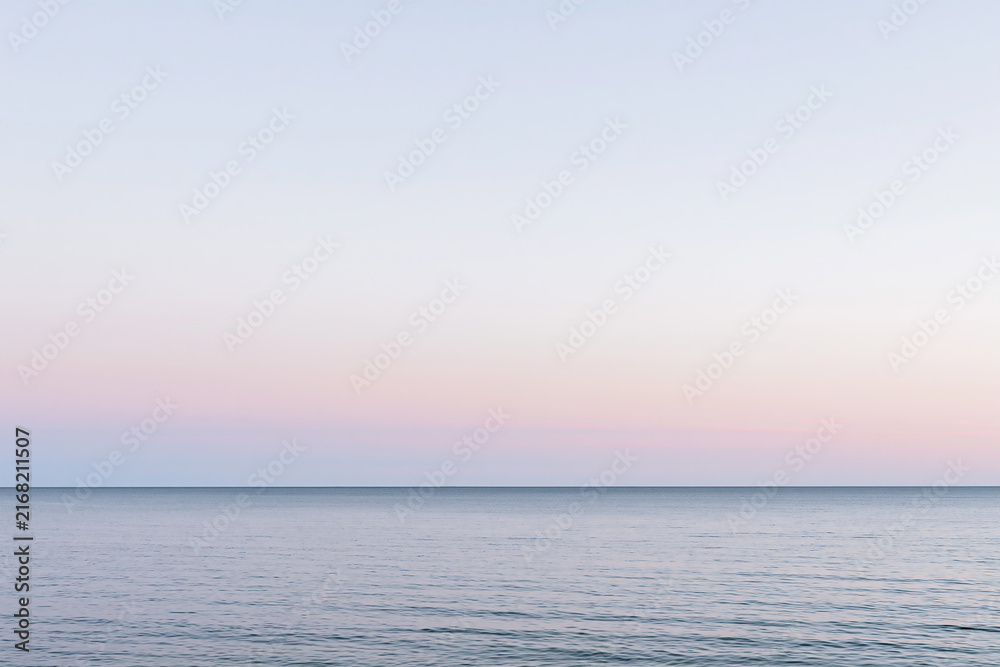 Fototapeta premium Serene Ocean Horizon Line Under Pastel Sunrise Sky