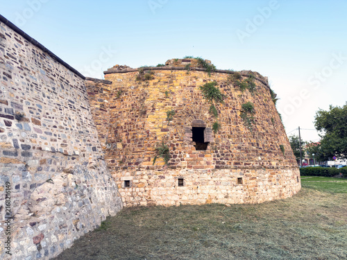 Weathered stone bastion and defensive walls above dry moat at Chios Castle, Greece
