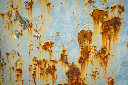 Canvastavla Close-up of a heavily rusted blue metal surface with orange corrosion stains, peeling paint, and distressed industrial texture