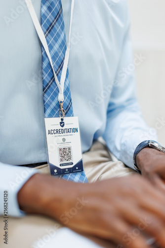 A businessman wears an accreditation badge at the workplace