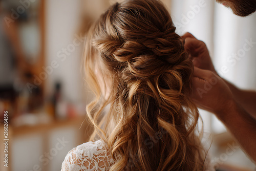 Bride getting her hair styled for wedding day with elegant updo.