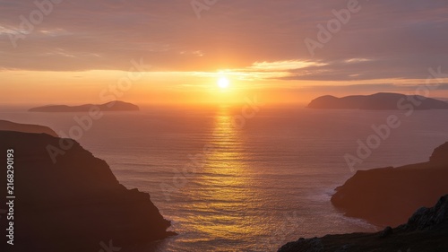 Golden sunset over calm ocean with silhouetted islands and sky reflections golden hour calm water