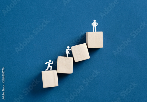 People figurines climbing wooden blocks career ladder
