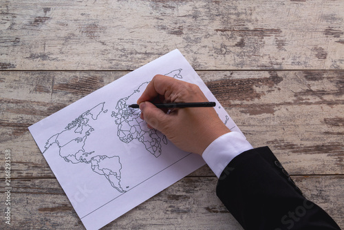 Obraz na plátně Business Professional Marking A World Map On Paper For Travel Planning And Strat