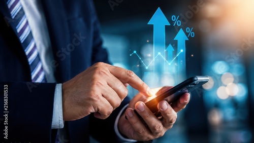 Businessman using a smartphone to analyze financial growth and rising interest rates.