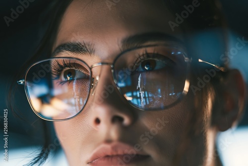 Close-up of businesswoman with a launching rocket reflected in eyeglasses