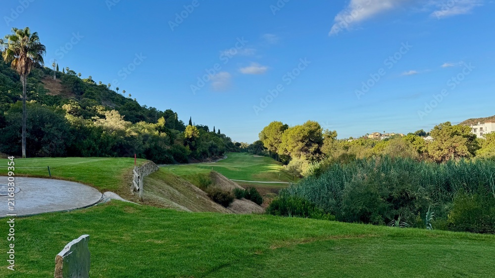 Fototapeta premium Scenic Golf Course Fairway Surrounded by Mediterranean Vegetation in Spain