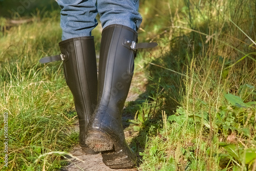 Foto Person wearing black rubber wellington boots hiking on a muddy forest path part 1