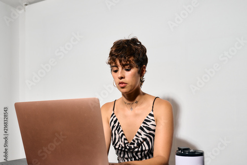 Businesswoman working at Office. DIrect flash shot. She focuses intently on her laptop screen, fingers poised over the keyboard. 